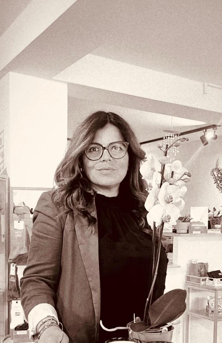 Karina dans sa boutique, aux côtés d’une orchidée