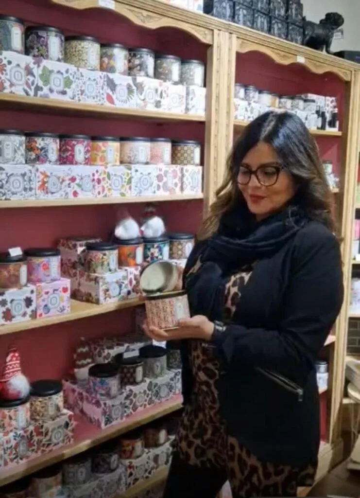 Karina présente une bougie parmi les rayons de la boutique